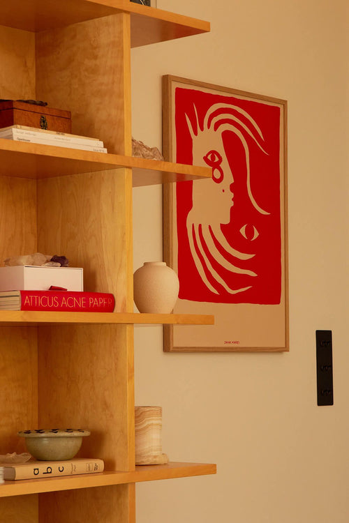 Wooden shelf with books and a vase, red poster on the wall