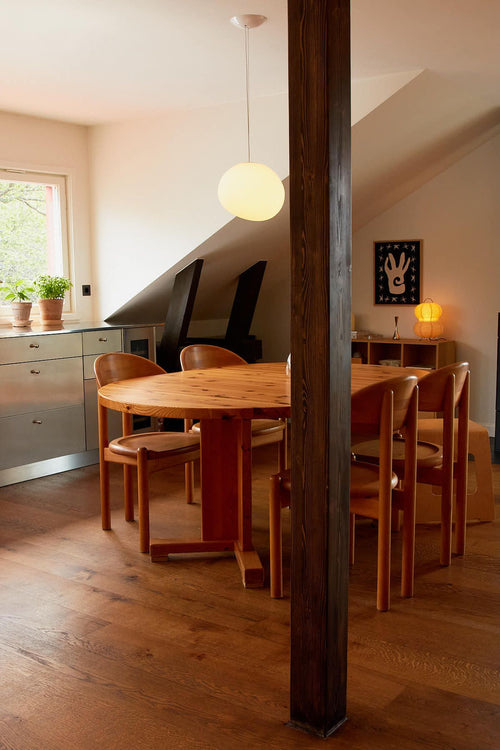 Dining area with wooden table and chairs in a home setting.
