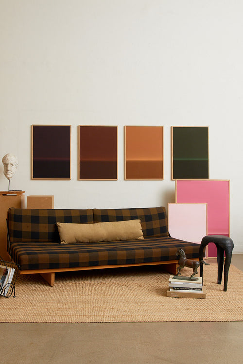 Art print with an abstract spray painting of a dark sky in deep brown tones. Styled in a minimalist interior.