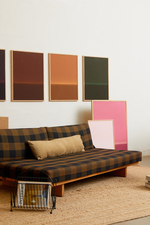 Art print with an abstract spray painting of a dark sky in deep green tones. Styled in a minimalist interior.