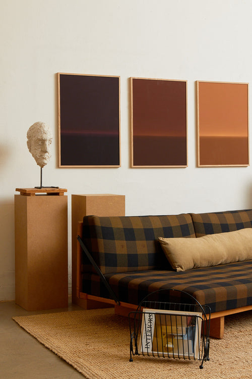 Art print with an abstract spray painting of a dark sky in deep brown tones. Styled in a minimalist interior.