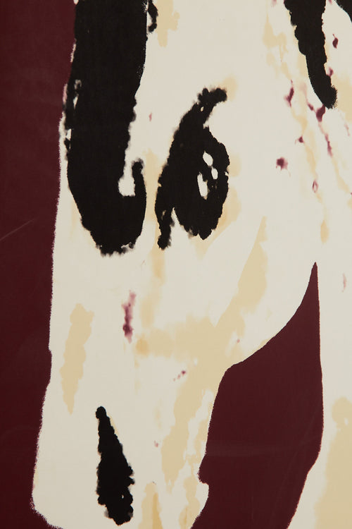 Art print with a stylized illustration of a horse head in light beige and black tones against a wine-red background, with an intentionally blurred and painterly feel. Styled in a minimalist interior.