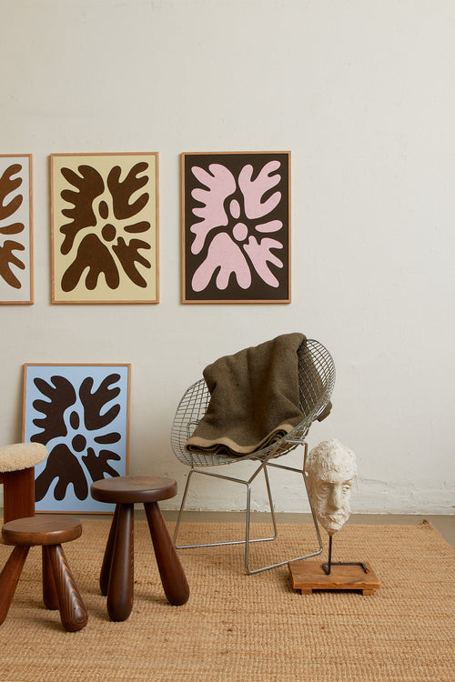Art print featuring a minimalistic motif in chocolate brown and pastel pink, with shapes that explore the space between abstraction and recognition through soft, fluid forms. Styled in a minimalist interior.