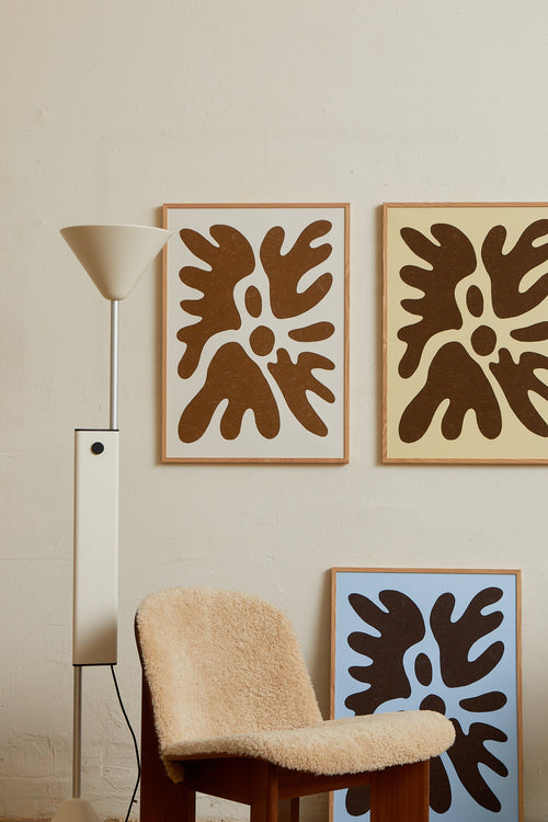 Art print featuring a minimalistic motif in warm brown and soft beige, with shapes that explore the space between abstraction and recognition through soft, fluid forms. Styled in a minimalist interior.