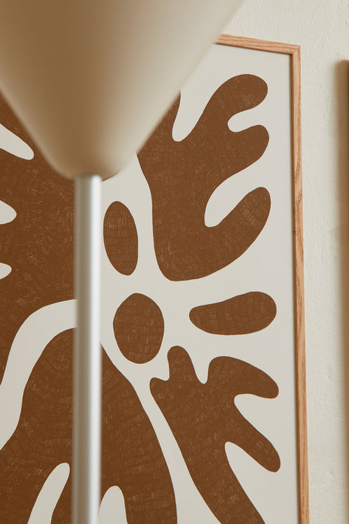 Art print featuring a minimalistic motif in warm brown and soft beige, with shapes that explore the space between abstraction and recognition through soft, fluid forms. Styled in a minimalist interior.