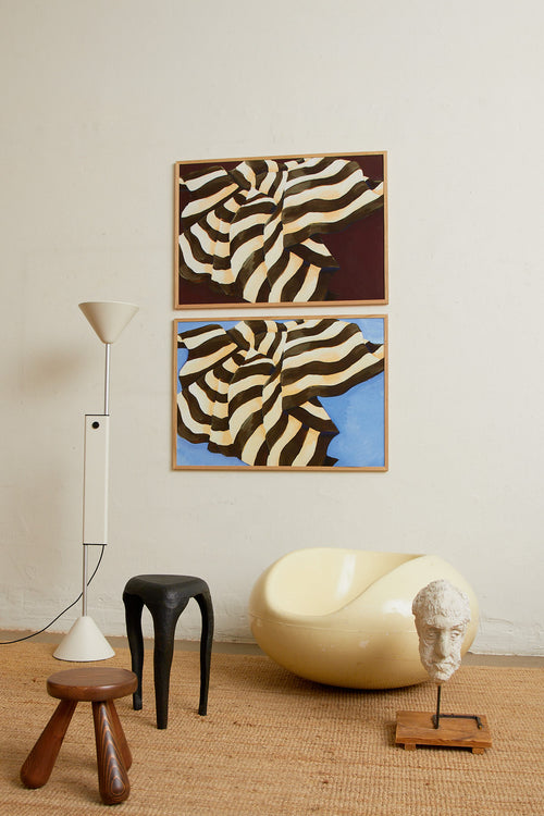 Art print featuring a painting of a plaid against a deep burgundy background, flowing with wide stripes in dark chocolate brown and creamy white. Styled in a minimalist interior.