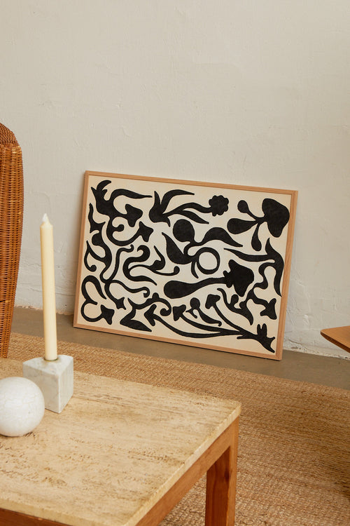 Art print with a minimalist illustration of black, organic, hand-drawn lines against an off-white background. Styled in a minimalist interior.