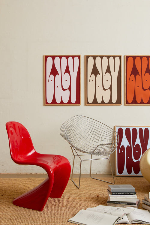 Art print featuring playful, bold typography of the word “Baby” in sand beige against a dark brown background. Styled in a minimalist interior.