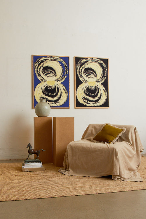 Art print with an abstract illustration of circular forms in light tones against a dark background, with a soft and organic expression. Styled in a minimalist interior.