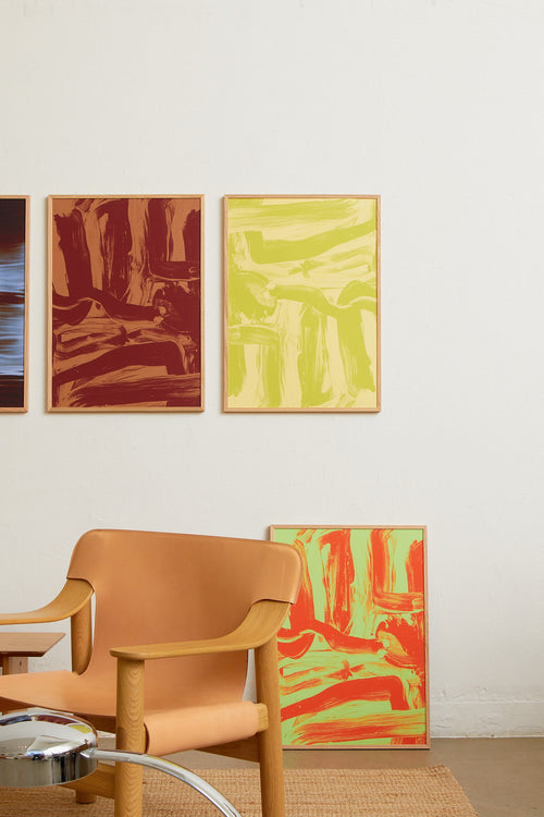 Art print featuring layered and sweeping brushstrokes in light yellow and green that create a sense of movement and tension across the surface. Styled in a minimalist interior.