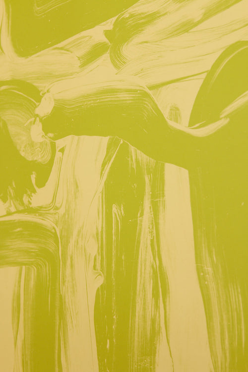 Art print featuring layered and sweeping brushstrokes in light yellow and green that create a sense of movement and tension across the surface. Styled in a minimalist interior.