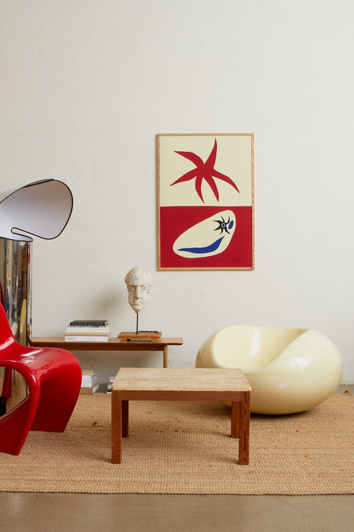 Art print with a graphic, minimalist artwork in red and off-white where organic shapes meet sharp symbols in a playful yet balanced expression. Styled in a minimalist interior.