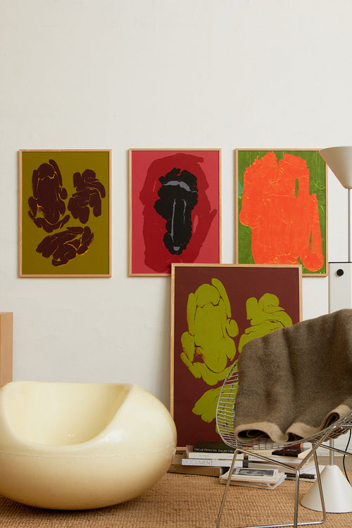 Art print featuring fragmented, rounded forms arranged in loose groupings across a deep brown surface, with subtle cracks and glowing edges. Styled in a minimalist interior.