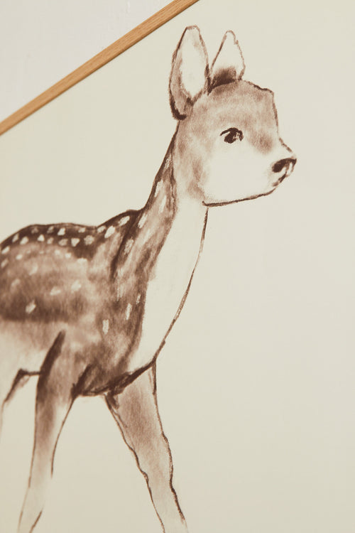 Art print with a stylized illustration of a fawn in gray-brown tones against a, with a soft and graphic expression. Styled in a minimalist interior.