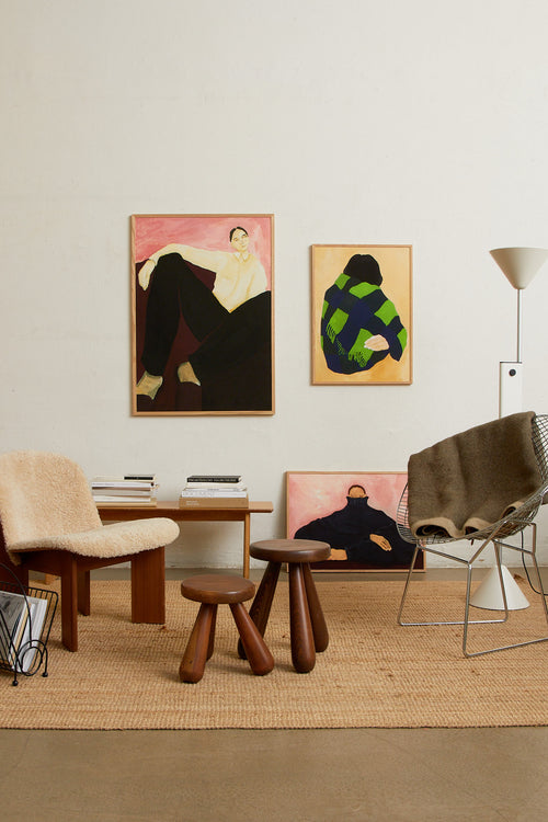 Art print featuring a painting of a person’s back, with a bright green shawl wrapped around the body against a beige background. Styled in a minimalist interior.