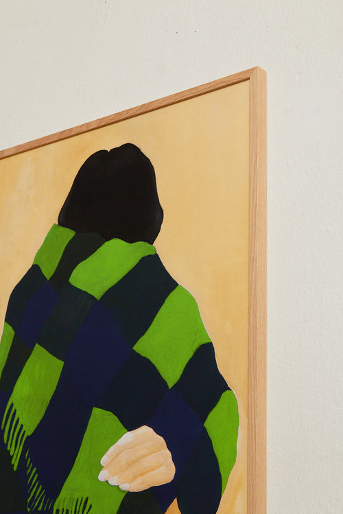Art print featuring a painting of a person’s back, with a bright green shawl wrapped around the body against a beige background. Styled in a minimalist interior.