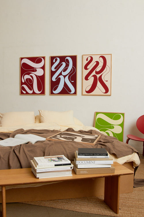 Art print featuring exploratory organic forms emerging in burgundy and blue. Styled in a minimalist interior.