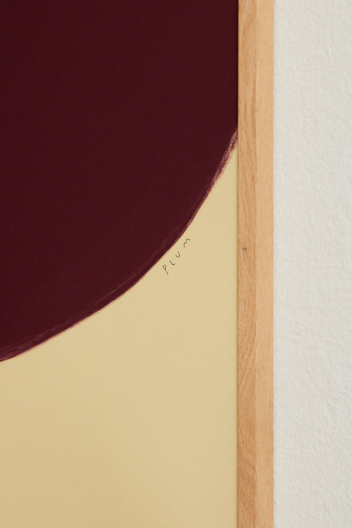 Art print with a minimalist illustration of a large, rounded color field in a wine-red tone against a light beige background. Styled in a minimalist interior.