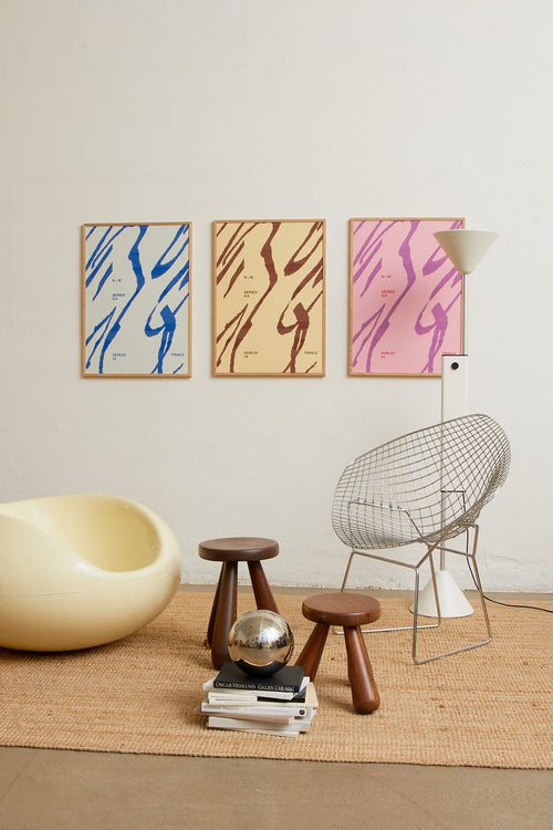 Art print with a graphic illustration of sweeping, organic forms built from dense lines, complemented by small text elements, in blue RAL colors. Styled in a minimalist interior.