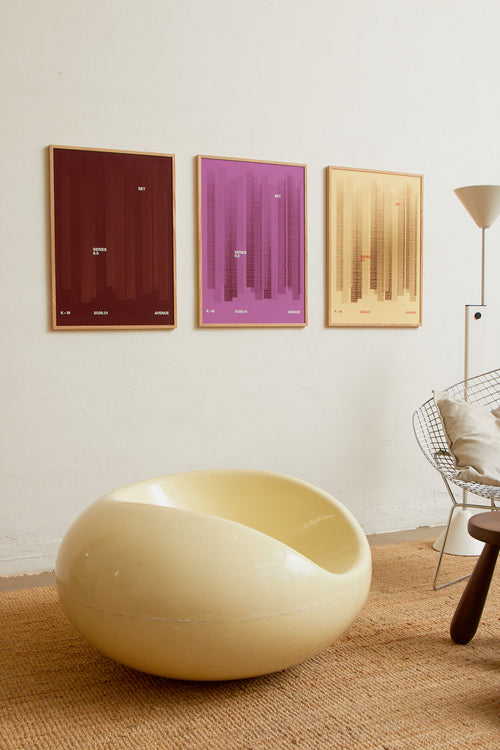 Art print with a graphic illustration of vertical fields built from dense lines, complemented by small text elements, in brown and red RAL colors. Styled in a minimalist interior.