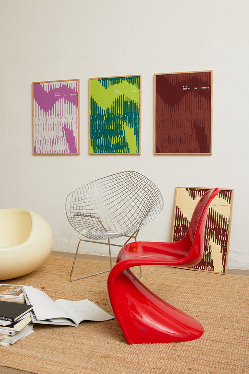 Art print with a graphic illustration of organic, vertical line patterns forming abstract shapes, complemented by small text elements, in purple RAL colors. Styled in a minimalist interior.