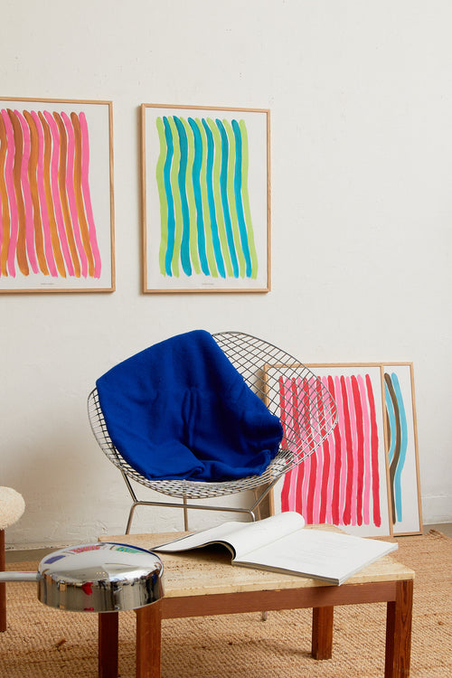 Interior scene with multiple colorful striped art prints and wooden furniture