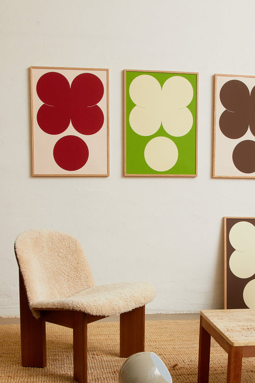 Art print featuring playful, bold typography of the letters X and O, hugs and kisses, in red against a beige background. Styled in a minimalist interior.