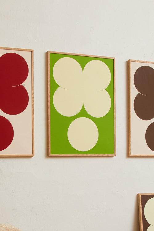 Art print featuring playful, bold typography of the letters X and O, hugs and kisses, in yellow-green against a bright green background. Styled in a minimalist interior.