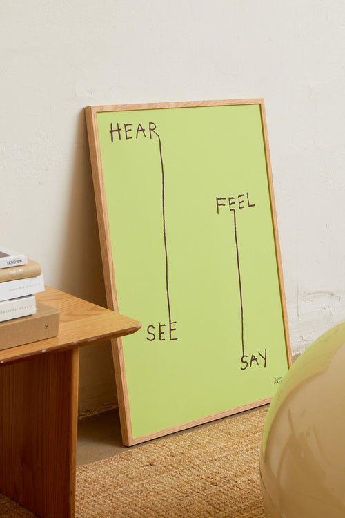 Green framed print styled on a wooden table in a modern interior