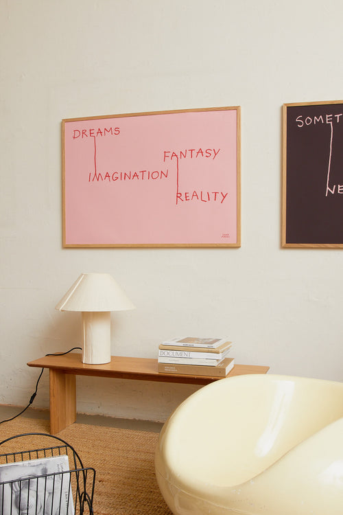 Art print featuring red handwritten lettering that connects words in an illustrative way on a pink background, creating a new context. Styled in a minimalist interior.