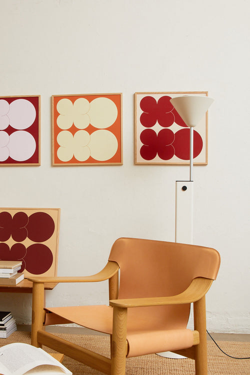 Square-format Art print featuring playful, bold typography of the letters X and O, hugs and kisses, in yellow against an orange background. Styled in a minimalist interior.