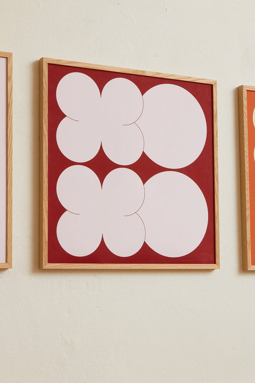 Square-format Art print featuring playful, bold typography of the letters X and O, hugs and kisses, in pink against a red background. Styled in a minimalist interior.