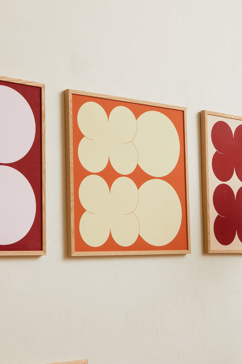 Square-format Art print featuring playful, bold typography of the letters X and O, hugs and kisses, in yellow against an orange background. Styled in a minimalist interior.